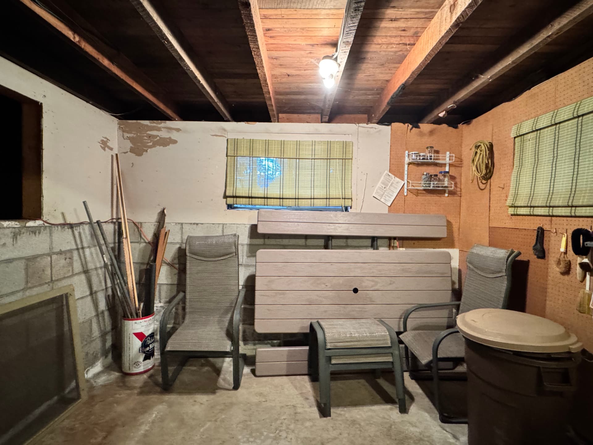 The lower level before, unfinished and used for storage under exposed ceiling joists